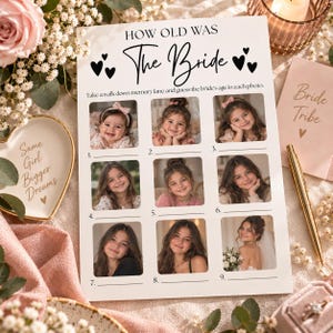 May include: A white paper game card titled How Old Was The Bride with black text and heart icons. The card features a grid of nine numbered photo slots showing a person at different ages, with blank lines for writing guesses below each image.