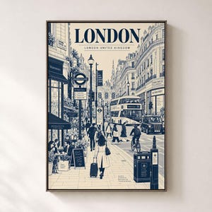 May include: A framed art print featuring a detailed illustration of a London street scene in navy blue and cream. The text reads LONDON, LONDON UNITED KINGDOM, WATERSTONES, UNDERGROUND, MONMOUTH, BURBERRY, and SAME STREETS BRIGHTER TOMORROWS.