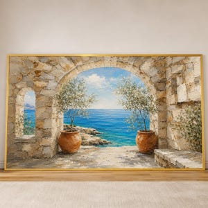Può includere: Un dipinto a olio in una cornice dorata raffigurante un arco in pietra che si affaccia su un mare blu brillante. Due vasi in terracotta contenenti piccoli alberi verdi poggiano su una terrazza in pietra sotto un cielo azzurro.
