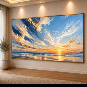 Op de afbeelding: Een grote rechthoekige wandkunstprint met een levendige zonsondergang boven een kalme oceaan. De lucht is gevuld met wervelende gouden en witte wolken tegen een diepblauwe achtergrond, die licht reflecteren op het natte zandstrand eronder.
