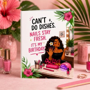 May include: A greeting card featuring an illustration of a person with dark curly hair and a white flower, sitting at a table with nail polish and a UV lamp. The text reads: CAN'T DO DISHES. NAILS STAY FRESH. IT'S MY BIRTHDAY. Decorated with pink hibiscus flowers.