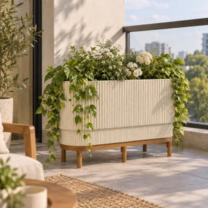 May include: A rectangular off-white planter with a vertical ribbed texture, supported by a wooden base with four legs. The planter is filled with various green leafy plants, trailing vines, and small white flowers, creating a dense arrangement.