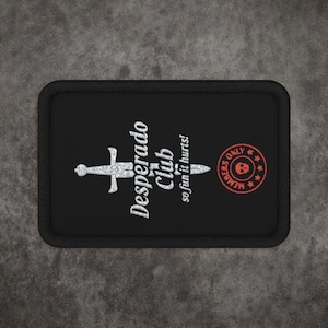 May include: A rectangular black patch with a white graphic of a sword and the text Desperado Club so fun it hurts. To the right is a circular red stamp design with the text MEMBERS ONLY and a small skull icon in the center of the circle.