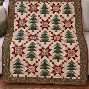 May include: A rectangular quilt featuring a repeating pattern of dark green pine trees and red star blocks on a cream background. The quilt is framed by a wide olive green border with a small floral print and finished with a thin red binding edge.