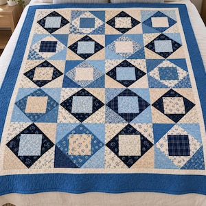 May include: A quilt featuring a grid of squares in shades of navy blue, light blue, and cream. The design incorporates various patterns including floral prints, plaids, and solid colors, all framed by a solid navy blue border.