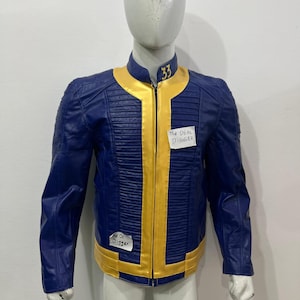 May include: A blue and yellow jacket featuring a stand-up collar with the number 33 embroidered in yellow. The jacket has a central yellow zipper placket, ribbed paneling on the chest, and two white paper labels with the text The DEAL DIGGER.