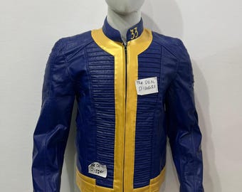 Può includere: Una giacca blu e gialla con colletto alla coreana e il numero 33 ricamato in giallo. La giacca presenta una chiusura centrale con zip gialla, pannelli a coste sul petto e due etichette di carta bianca con il testo The DEAL DIGGER.