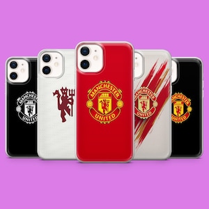 Op de afbeelding: Vijf smartphonehoesjes met Manchester United branding. De ontwerpen omvatten een zwarte hoes met een wit logo, een witte met een bordeauxrood duivel-icoon, een rode met een gekleurd embleem, een witte met rode penseelstreken en een zwarte met een embleem.