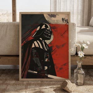 Könnte beinhalten: Ein gerahmter vertikaler Kunstdruck mit einer stilisierten Illustration von Darth Vader in schwarzem Helm und Rüstung. Die Figur steht vor einem kräftigen roten Hintergrund mit einer großen mondähnlichen Kugel und einem Lichtschwertgriff.