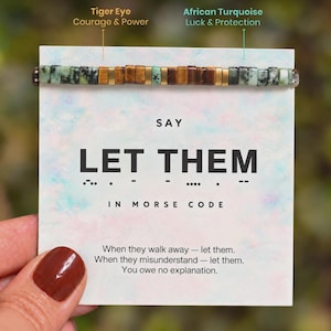 May include: A bracelet featuring alternating rectangular tiger eye and African turquoise beads with gold-tone spacers, displayed on a card that reads SAY LET THEM IN MORSE CODE, followed by the text: When they walk away — let them. When they misunderstand — let them. You owe no explanation.