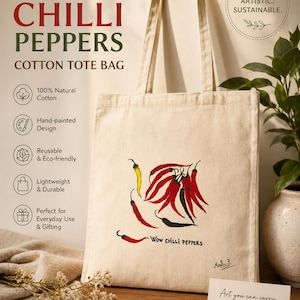 May include: A natural-coloured cotton tote bag featuring a hand-painted illustration of red and yellow chilli peppers. The text "Wow chilli peppers" is printed below the peppers. The bag has two long shoulder straps and a rectangular shape.