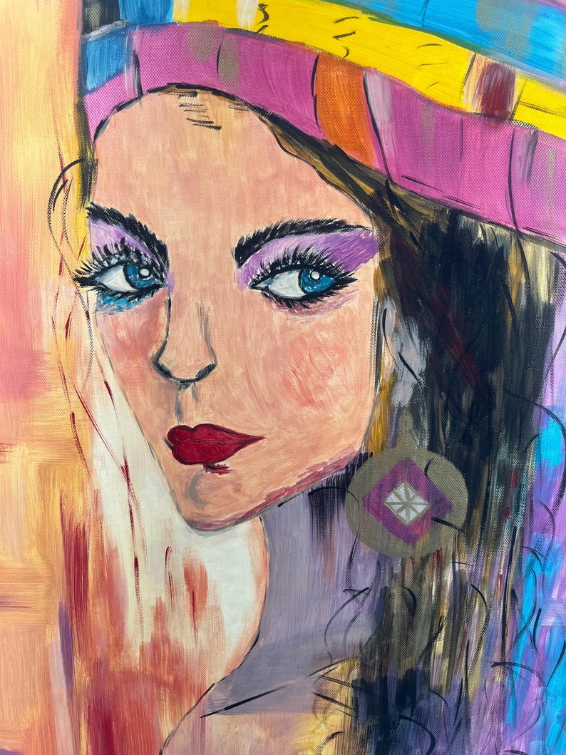 Peut inclure: Une peinture acrylique sur toile repr&eacute;sentant le portrait d'une personne aux yeux bleus, aux cheveux fonc&eacute;s et aux l&egrave;vres rouges. Le sujet porte une coiffe rose et jaune ainsi qu'une boucle d'oreille circulaire avec un losange violet et une croix blanche.