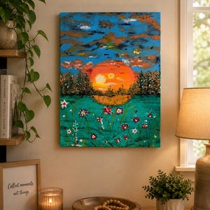 May include: A rectangular canvas painting featuring a vibrant orange sun setting over a dark forest line, set against a textured blue sky with clouds. The foreground displays a teal field filled with small, scattered red and white flower blossoms.