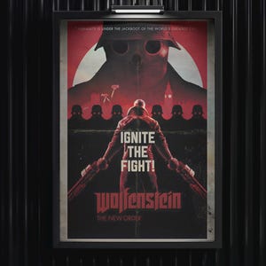 May include: A framed poster for Wolfenstein The New Order featuring a central figure holding two weapons against a red background. The text reads: HUMANITY IS UNDER THE JACKBOOT OF THE WORLD'S GREATEST EVIL, IGNITE THE FIGHT!, and Wolfenstein THE NEW ORDER.