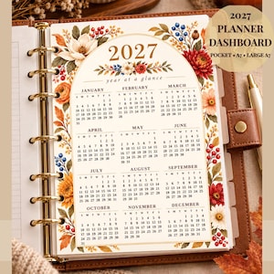 May include: A 2027 year at a glance planner dashboard insert featuring a floral arch design with red, orange, and blue flowers. The page includes a full calendar for all twelve months and the text 2027 PLANNER DASHBOARD POCKET A7 LARGE A7.