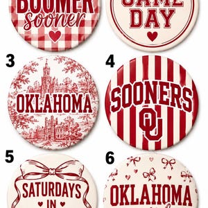May include: Six circular buttons featuring red and white designs. Button 1 has a red gingham pattern with the text BOOMER sooner and a heart. Button 2 says GAME DAY with a bow and heart. Button 3 shows an Oklahoma campus illustration. Button 4 has red stripes and the text SOONERS with an OU logo. Button 5 says SATURDAYS IN Norman with a bow. Button 6 says OKLAHOMA girl with bows and hearts.