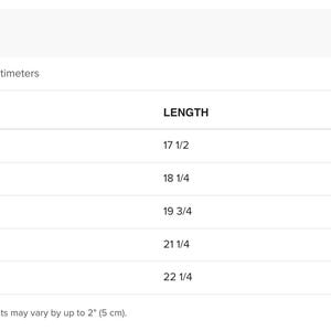 May include: A size chart table with black text on a white background. It lists sizes S, M, L, XL, and 2XL with corresponding length and width measurements in inches. The table includes a note that product measurements may vary by up to 2 inches.