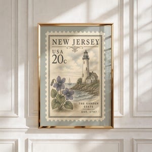 May include: A framed wall art print featuring a vintage-style postage stamp design of New Jersey. The illustration depicts a lighthouse on a rocky coast, a sailboat, and purple violets. Text includes NEW JERSEY, USA 20c, and THE GARDEN STATE EST. 1787.