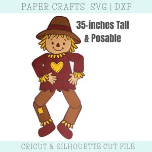 May include: A paper craft scarecrow design, 35-inches tall and posable. The scarecrow has a brown hat, a maroon shirt with a yellow heart, and brown pants. The design is for Cricut and Silhouette cut files.