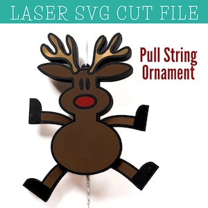 May include: A brown reindeer pull string ornament with a red nose and gold antlers. The ornament is designed to be hung from a string.