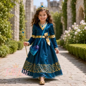 Puede incluir: Un vestido de manga larga en color verde azulado oscuro con cintura dorada, dobladillo con patrón dorado y cuello en V dorado. El conjunto incluye una corona dorada con una gema azul, un cetro dorado con un corazón azul y un bolso de lentejuelas.