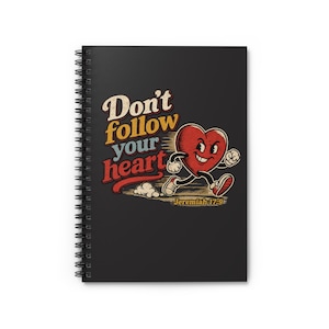 May include: A black spiral-bound notebook featuring a graphic of a cartoon heart with arms and legs running. The text reads Don't follow your heart and Jeremiah 17:9 in a retro, multi-colored font. The design includes a distressed texture.
