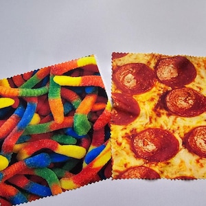 Peut inclure: Deux chiffons en microfibre colorés, l'un avec un motif de vers gélatineux et l'autre avec un motif de pizza au pepperoni.