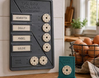 May include: A dark gray wall-mounted egg tracking board titled THE EGG EXCHANGE with four name slots for Henrietta, Dolly, Mabel, and Goldie, each with a circular numbered dial. A smaller matching teal sign reads EGGS TODAY with a dial.