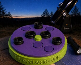 May include: A round, lime green and purple plastic accessory holder labeled THE OCULAR ROTUNDA, featuring four black telescope eyepieces inserted into the top surface, a central lime green knob, and several empty circular slots for additional storage.