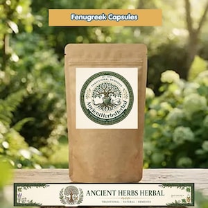 Pode incluir: Uma bolsa de papel castanho rotulada como Fenugreek Capsules com um logótipo circular que mostra uma árvore e um almofariz com pilão. O texto diz Ancient Herbs Herbal, Traditional Remedies, Est. 2022 e Nature's Wisdom. A bolsa está centrada.