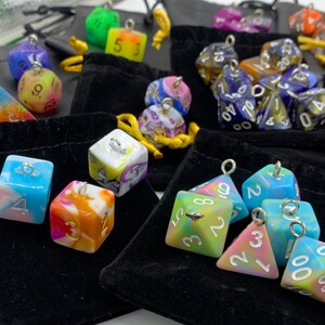 May include: Assortment of colorful dice with silver accents and numbers. The dice are in small velvet bags.