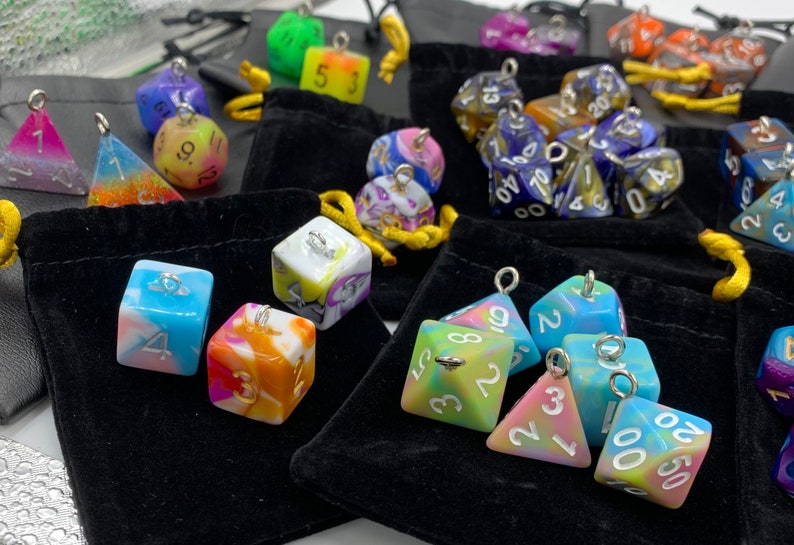 May include: Assortment of colorful dice with silver accents and numbers. The dice are in small velvet bags.