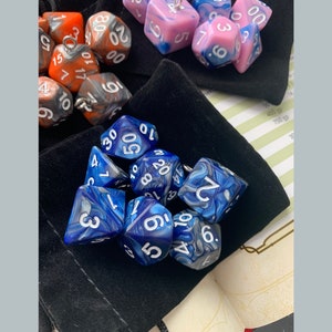 May include: A collection of blue and white marbled dice with white numbers. The dice are in a black velvet bag.