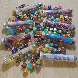 May include: A collection of colorful glass test tubes filled with various colored dice. The test tubes are labeled with names like "Imogen", "Refresh Cut Grass", "Laundna", "Chetney", and "Dorian".
