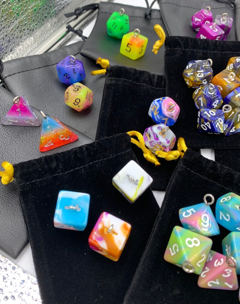 May include: Assortment of colorful dice with different numbers and patterns. The dice are made of resin and have a glossy finish. They are packaged in small velvet bags.