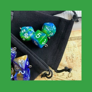 May include: Four blue and green dice with white numbers on a black velvet bag. The dice are in a variety of shapes and sizes.