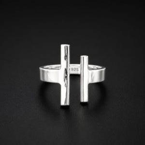 May include: A polished sterling silver open ring featuring two vertical bars of varying heights extending from the band. The inner surface of the band is clearly stamped with the hallmark 925, indicating the silver content of this jewellery piece.