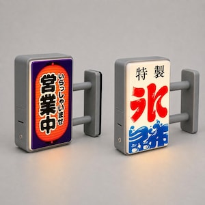 Puede incluir: Dos letreros rectangulares de pared con marcos grises y dos barras de soporte horizontales. El letrero izquierdo presenta un fondo morado con un gráfico de linterna roja y texto en japonés. El derecho tiene un fondo blanco con texto en japonés rojo y azul.