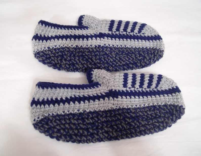 May include: A pair of crocheted slippers in blue and gray with a striped pattern.