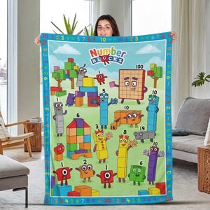 Op de afbeelding: Een rechthoekige fleece deken met het Numberblocks-logo en diverse kleurrijke blokfiguren met cijfers. De rand toont een herhalende reeks cijfers en wiskundige symbolen op een blauwe achtergrond tegen een lichtgroen landschap.