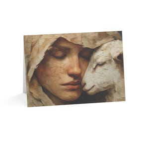 May include: A greeting card featuring an oil painting style illustration of a person with closed eyes wearing a hooded garment, resting their cheek against the head of a white lamb. The artwork uses textured brushstrokes in shades of beige, cream, and white.