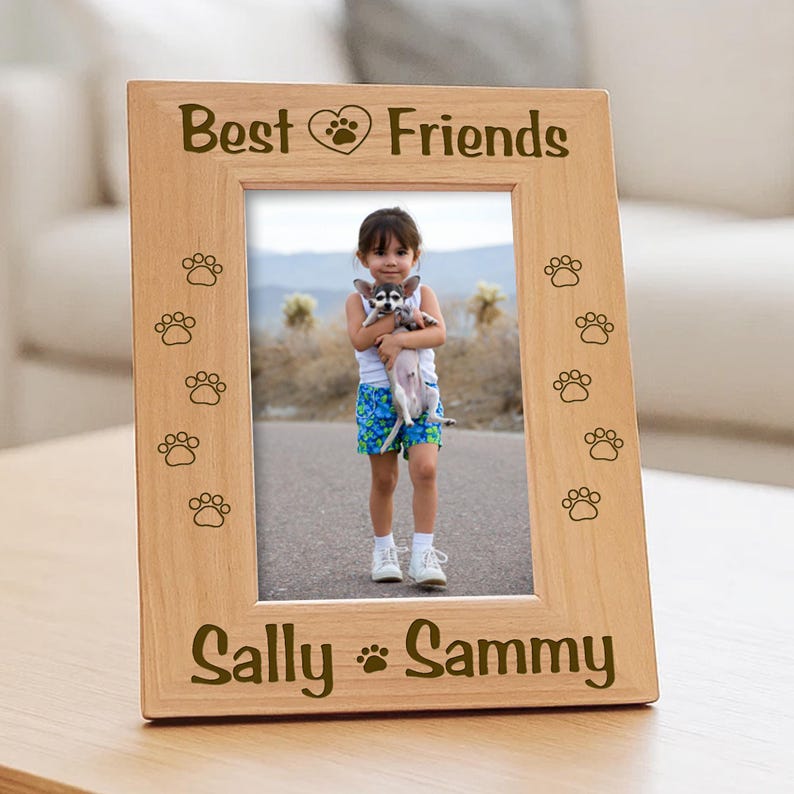 Vertical wood picture frame featuring laser-engraved paw prints along the sides. the text Best Friends with a heart icon on top panel, and the bottom border features the names.