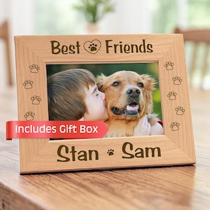 May include: A light-coloured wooden picture frame featuring the engraved text Best Friends with a heart and paw print icon at the top, and the names Stan and Sam with a paw print icon at the bottom, surrounded by small engraved paw print designs.
