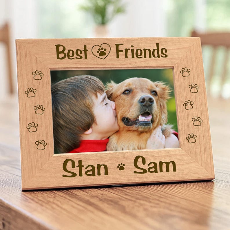 Wood picture frame featuring laser-engraved paw prints along the sides. Engraved text Best Friends with a heart icon on top panel, and the bottom border features the names.