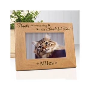 May include: A light brown wooden picture frame with a horizontal orientation. The top border is engraved with the text "Thanks for everything, I had a Wonderful Time!" and paw prints. The bottom border is engraved with the name "Miles" and paw prints.