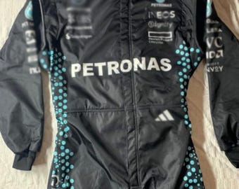 May include: A black long-sleeve racing suit featuring the PETRONAS logo across the chest, an Adidas logo, and various sponsor branding. The suit includes a teal dot pattern along the sides and the name GEORGE printed vertically on the leg.