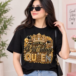 Könnte beinhalten: Ein schwarzes Kurzarm-T-Shirt mit einem Grafikdruck und dem Text IT'S MY Birthday QUEEN. Das Design zeigt eine goldene Krone, schwarze und goldene Luftballons, Herzformen und Tiermuster mit diamantartigen Akzenten.