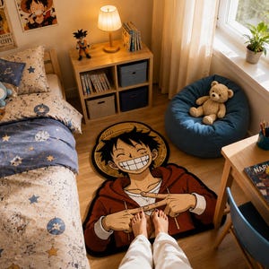 Op de afbeelding: Een gevormd vloerkleed met een grote, kleurrijke illustratie van het anime-personage Monkey D. Luffy met een strooien hoed en een rode hoodie, waarbij de handen in een specifiek gebaar zijn geplaatst, liggend op een houten vloer.