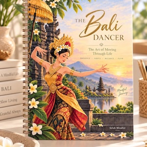 May include: A spiral-bound notebook titled The Bali Dancer: The Art of Moving Through Life. The cover features an illustration of a dancer in traditional Balinese attire, a golden umbrella, a temple, and a sunset landscape with white flowers.
