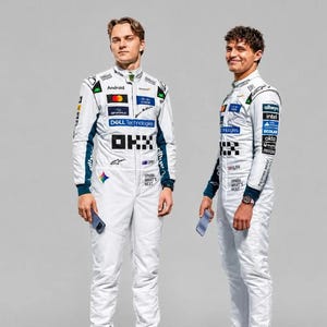 Pode incluir: Dois macacões de corrida brancos com painéis laterais azul-escuro e vários logotipos de patrocinadores, incluindo OKX, Dell Technologies, Cisco e Android. Os trajes exibem o texto Spark What's Next e um ícone de arco-íris.